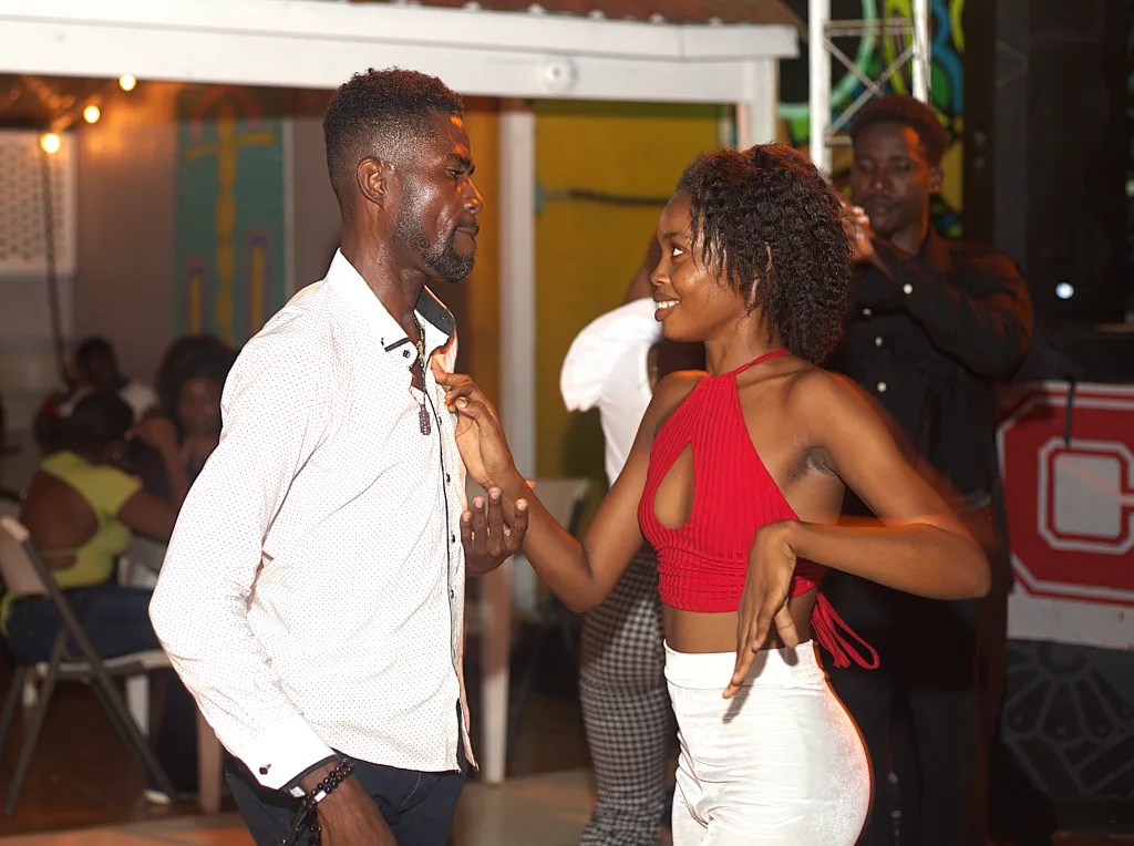 Une femme regarde affectueusement son partenaire de danse lors de leur sortie au Lakay Restaurant à Cap-Haïtien, le 2 octobre 2025. Photo par Onz Chéry / The Haitian Times.