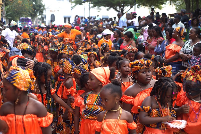 Students from Institution Saint-François Xavier, an all-girls Catholic school, stand along a road before the start of Le Carnaval des Tout-Petits in Cap-Haïtien on Feb. 12, 2026. Photo by Onz Chéry/The Haitian Times