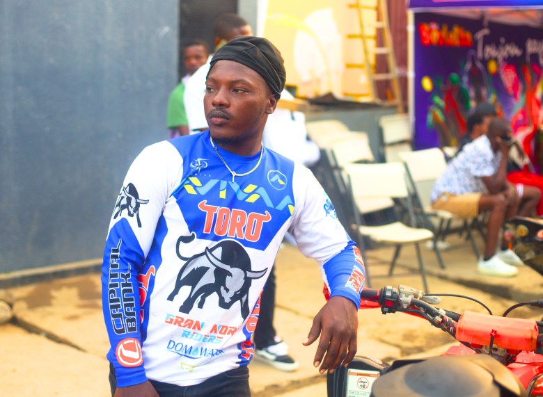 Un motard se tient à côté de sa moto en rue 24A, avant le début de la Ruff Ryders Block Party le 7 mars 2026. Photo par Onz Chéry / The Haitian Times.