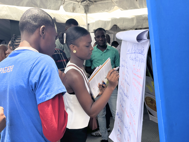 Des enfants au pavillon de l’UNESCO écrivent ce que Haïti représente pour eux lors de la 32e édition de Livres en Folie à l’hôtel El Rancho à Pétion-Ville le jeudi 4 juin 2026. Photo by Juhakenson Blaise / The Haitian Times