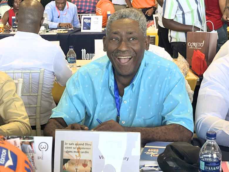 L’écrivain haïtien Gary Victor tout joyeux lors de la 32e édition de Livres en Folie à l’hôtel El Rancho à Pétion-Ville, le jeudi 4 juin 2026. Photo by Juhakenson Blaise / The Haitian Times