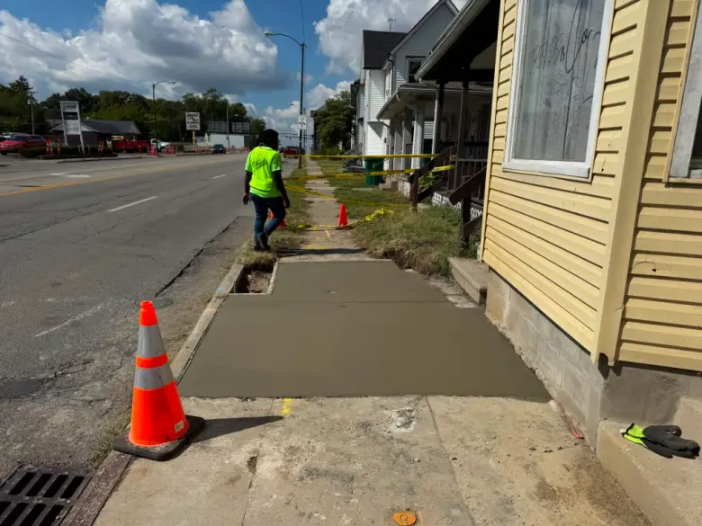 Les employés de Z-Remodeling & Hardscaping analysant le béton coulé alors qu’il sèche devant une maison en juillet 2025. Photo de Z-Remodeling & Hardscaping
