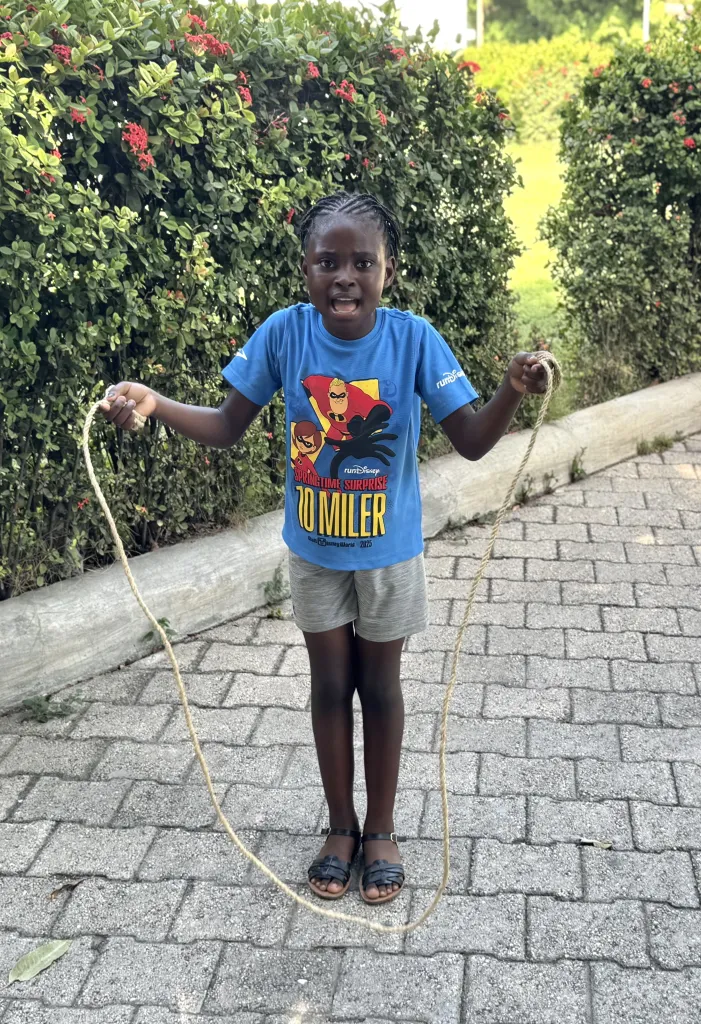 A young girl jumps rope during “Let’s Play Together” on Saturday, Aug. 15, 2026, at Lycée Anacaona in Léogâne, Haiti. Photo by Daniella Saint-Louis for The Haitian Times.
