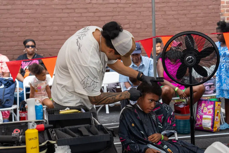 A youngster receives a fresh haircut during the community back-to-school fair at Maranatha Seventh-day Adventist Church in Newark, New Jersey, on Sunday, Aug. 30, 2026. Photo by Fred Cayemitte/The Haitian Times