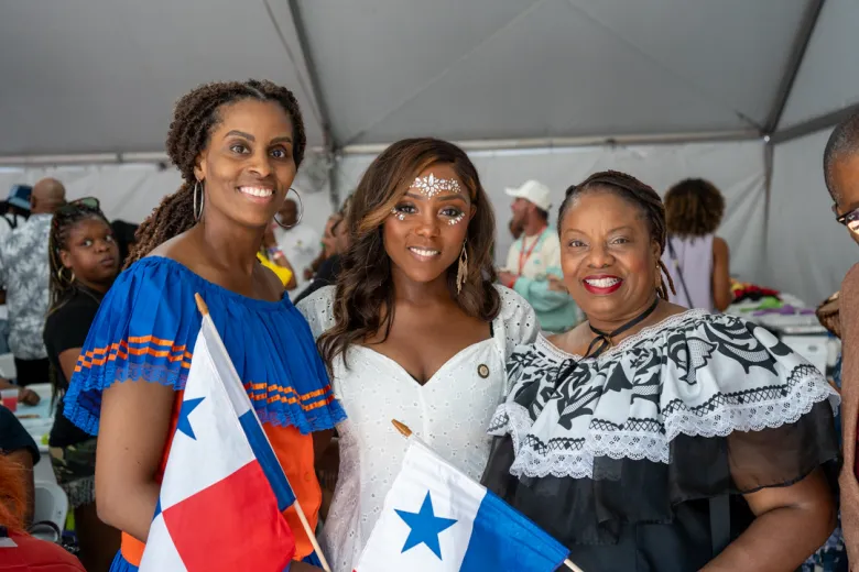 La conseillère Farah Louis (au centre) pose avec deux participants tenant des drapeaux panaméens lors du petit-déjeuner VIP annuel de WIADCA à Brooklyn, le 7 septembre 2026. L’événement a rassemblé des représentants et des soutiens des communautés caribéennes avant le défilé annuel. Photo par Fredner Caimite / The Haitian Times.