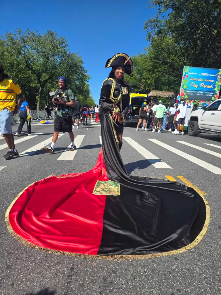 A masquerader honoring revolutionary heroine Sanité Bélair dons the historic red and black attire, echoing the colors of Haiti’s original republic flag. Photo by Darlie Gervais for The Haitian Times.