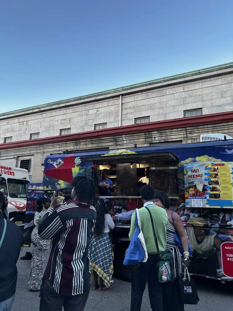 Attendees gather at Nao’s Caribbean Flavors, a Haitian food truck serving traditional Haitian cuisine, during CultureCon 2026 at the Brooklyn Navy Yard. Photo by Catherine Roth / The Haitian Times
